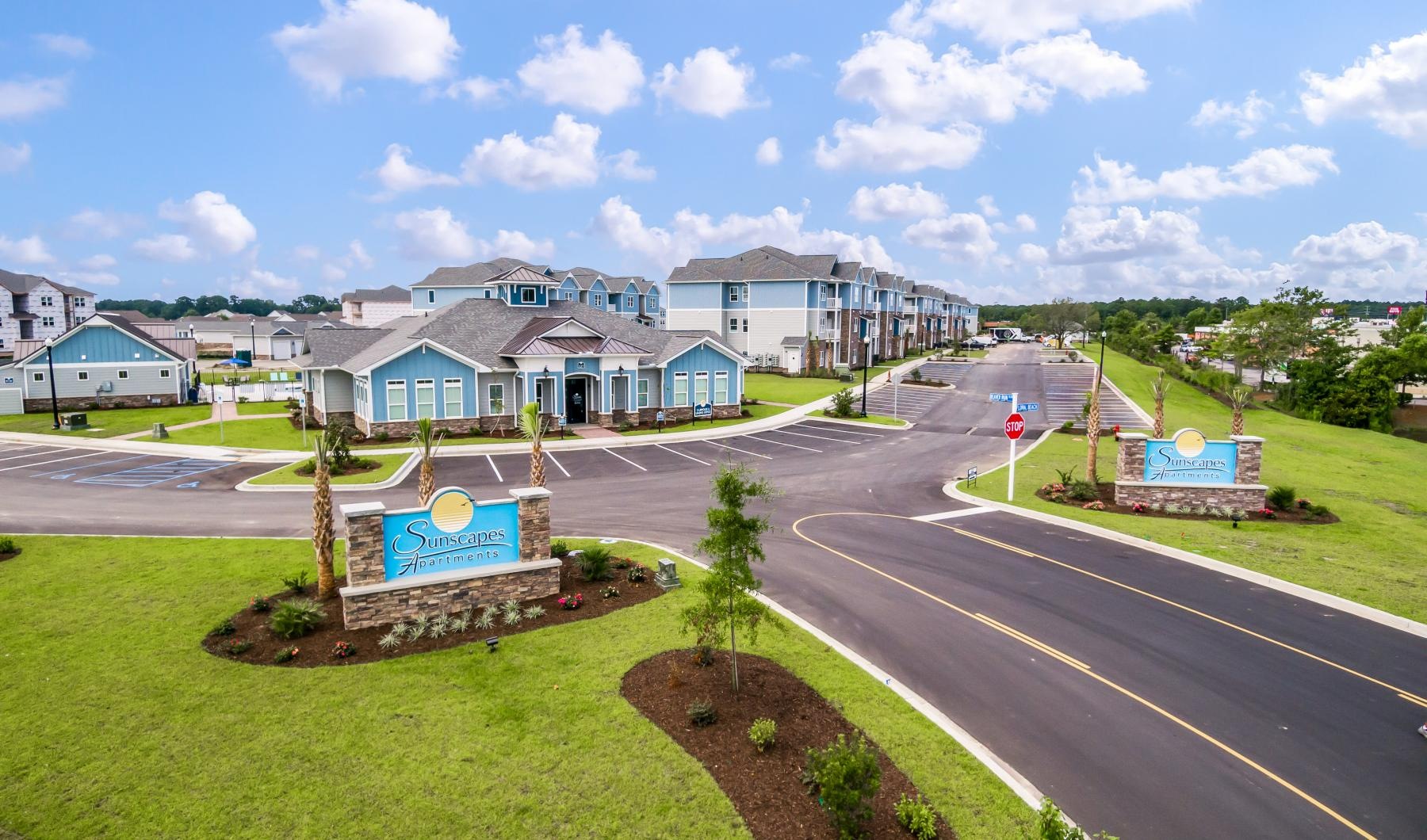 a road with with a sign and buildings along it